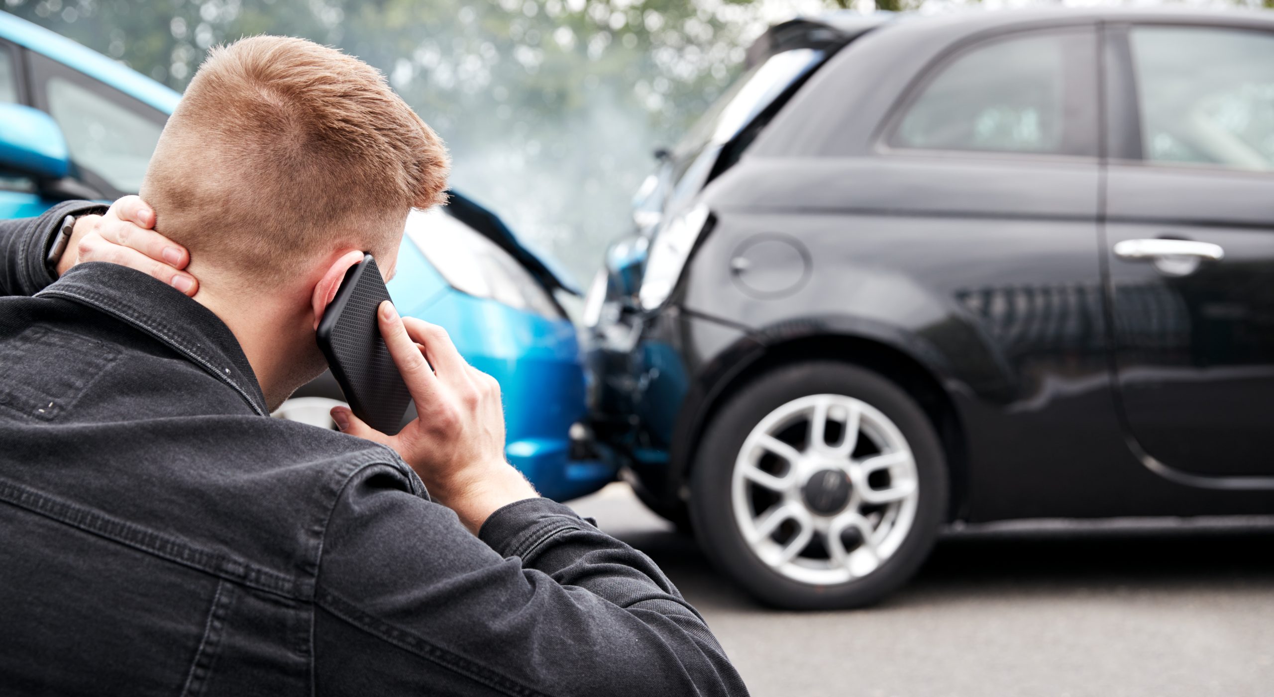 Injured man on the phone after a car accident.