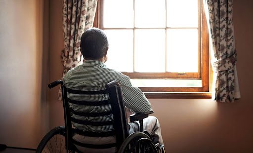 Elderly man in a wheelchair looks out his window in a Dunbar, WV, nursing home